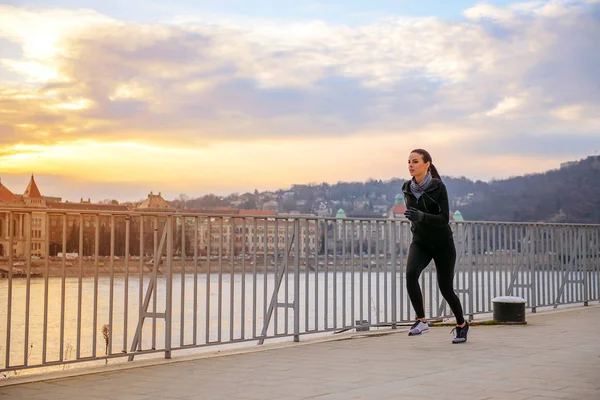 Νεαρή γυναίκα τρέχει στο ηλιοβασίλεμα — Φωτογραφία Αρχείου